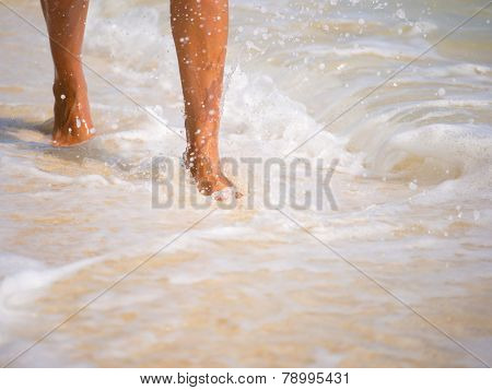 Woman walking on the sandy beach - Selective focus