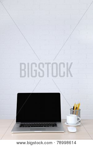 Modern laptop on table, on white wall background