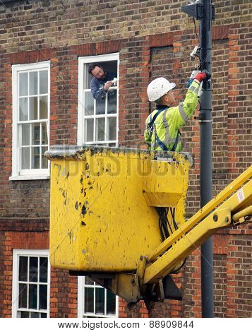 Worker paints a street lamp