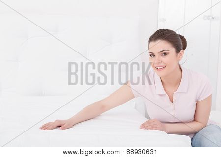 Young beautiful woman making bed