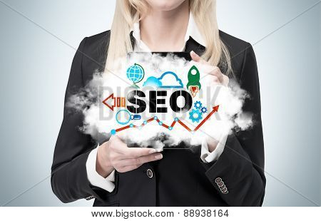 Blonde Businesswoman Is Holding A Cloud As A Metaphor Of 'seo'