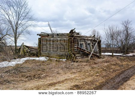Collapsed wooden house without a roof in the countryside