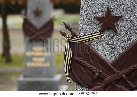 Red star and the Ribbon of Saint George at the Soviet War Memorial with graves of Soviet soldiers fallen in the last days of World War II at the Olsany Cemetery in Prague, Czech Republic.