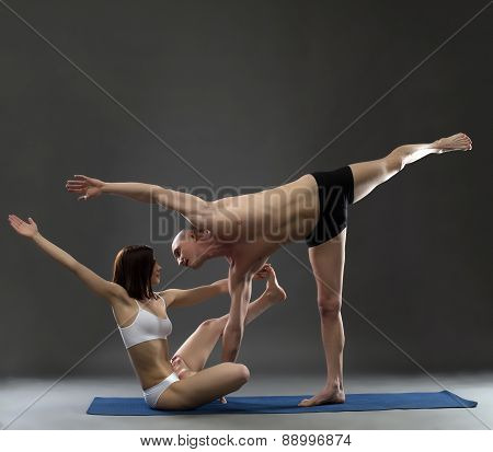 Paired yoga. Instructors posing in complex asana