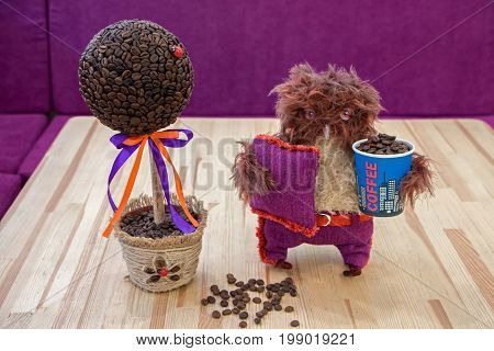 Handmade composition 'The money tree' made of coffee beans decorated with Ladybug DIY. Nearby stands owlet handmade and keeps the glass with coffee beans.
