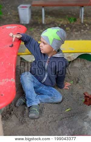 boy playing on the playground at bright summer day