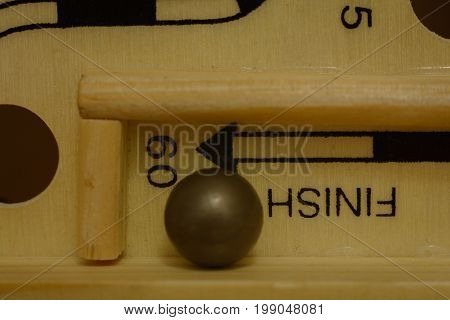 closeup of steel ball at the finish line of a labrynth
