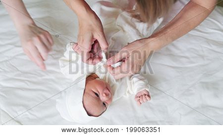 Mother is swaddling her child - newborn baby infant, close up