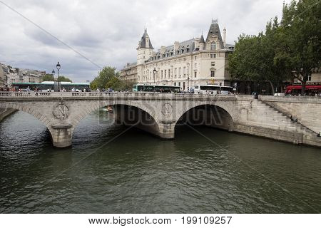 PARIJS , FRANKRIJK - JULY 23 ,2017:Old stone bridge with round bends over the river seine in paris. Around the bridge, tourists and buses travel