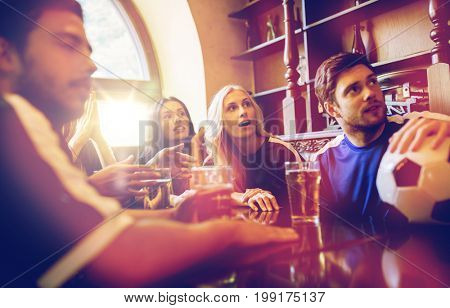 people, leisure and sport concept - happy friends or football fans drinking beer and watching soccer game or match at bar or pub