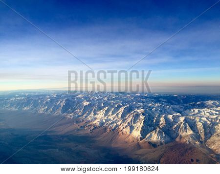 Flying over Sierra Mountains in Winter at Sunrise.