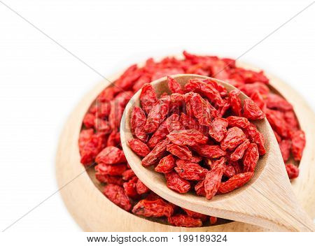 Red dried goji berries wolfberry or lycium chinese herbal medicine in wooden spoon on white background.
