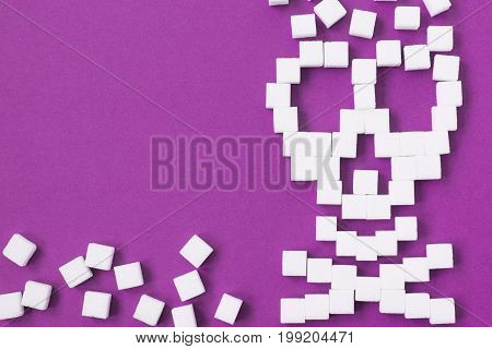 The skull made from sugar cubes. Sugar Kills. Blue background. diabetes concept. Suggesting dieting concept. Unhealthy white sugar concept. Copy space. Space for text.