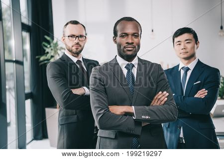 group of multiethic businessmen with folded arms looking at camera