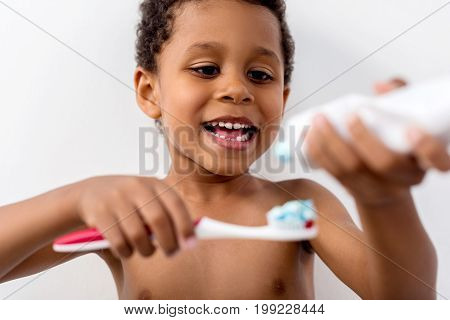 Kid Applying Tooth Paste On Brush