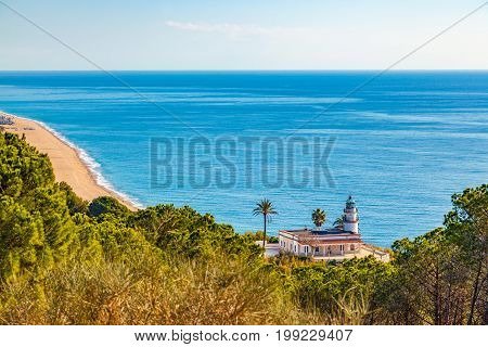 The famous lighthouse near Calella Spain overlooking the blue Mediterranean Sea.