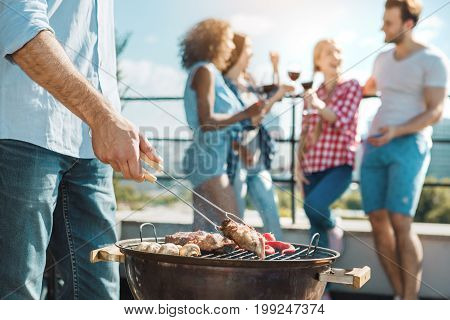 Group of people having barbecue party cooking meat