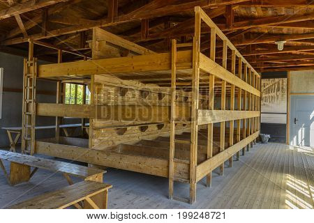 Dachau Concentration Camp Germany - August 29 2015: Inside sleeping quarters with wooden bunk beds from barrack room showing terrible prisoners living conditions from extermination camp.