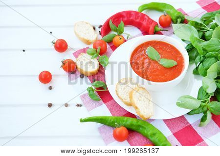 Cold summer tomato dish. Gaspacho soup with toast cherry tomatoes pepper basil herbs.