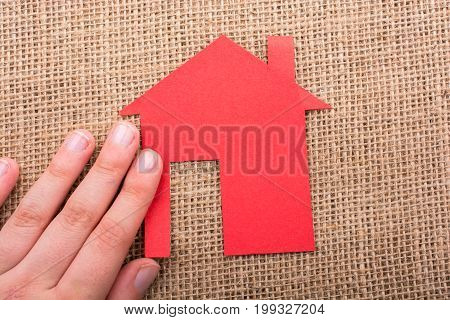 Hand Holding A Paper House On Canvas