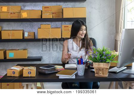 Young asian teenager owner business woman work at home for online shopping writing the order and prepaing package the product with office equipment entrepreneur and alpha generation life style concept