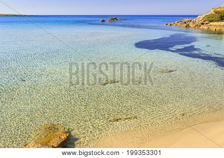 Summer seascape,Apulia coast: Marina di Pulsano beach (Taranto). The coastline is characterized by a alternation of sandy coves and jagged cliffs overlooking a truly clear and crystalline sea.