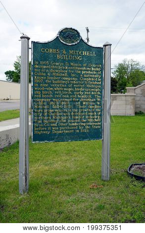 CADILLAC, MICHIGAN / UNITED STATES - MAY 31, 2017: 
A sign, placed by Department of State's Michigan History Division, describes the historical significance of the Cobbs and Mitchell Building in Downtown Cadillac.
