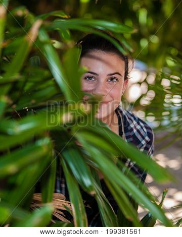Mysterious teenager girls face emerging from the foilage.