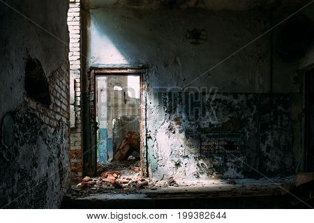 Abandoned industrial interior building, door in bright light and shadow, toned