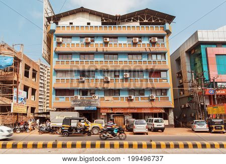 MANGALORE, INDIA - FEB 24, 2017: City street with vehicles driving past modern buildings with Air conditioners on February 24, 2017. With population of 500000 Mangalore is chief port city of Karnataka