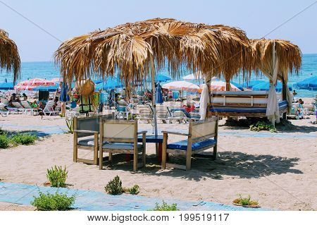 July, 2017 - A canopy of palm leaves above the tables of a beach cafe in Alanya, Turkey.