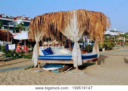 July, 2017 - A canopy of palm leaves above the tables of a beach cafe in Alanya, Turkey.