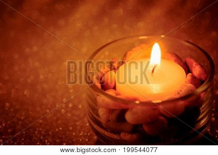 Abstract background for pray or meditation caption. Still life golden candle light with reflection on golden blurred bokeh background.