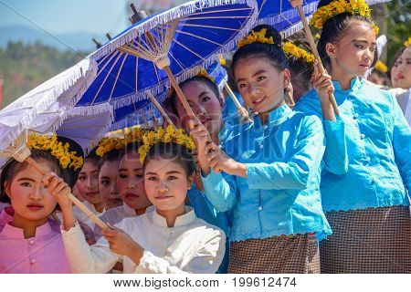 CHIANGMAI THAILAND - JANUARY 25 2015: Indigenous little girls with traditional costume holding umbrellas and dancing in traditional style in parade of 22nd Traditional Skirt Fabric and The Indigenous Product and Culture Festival in Mae Chaem Chiangmai Tha