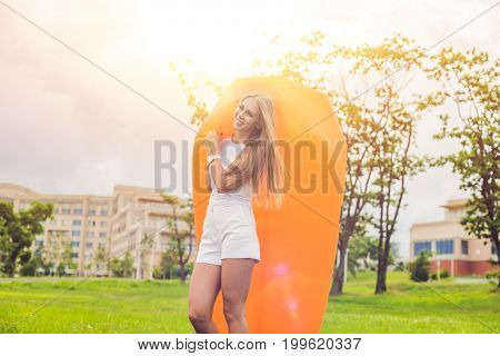 Young Woman Resting On An Air Sofa In The Park.