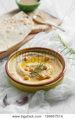 Homemade humus in ceramic bowl with tahina and lavash. Selective focus.