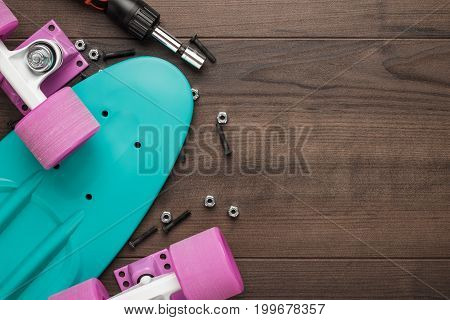 plastic mini cruiser board disassembled. mini cruiser on wooden background. mini cruiser board on brown table. top view of plastic mini cruiser with copy space