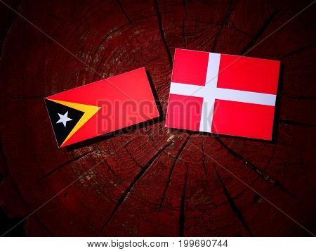 East Timorese Flag With Danish Flag On A Tree Stump Isolated