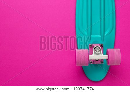 plastic mini cruiser board on deep pink with background with copy space