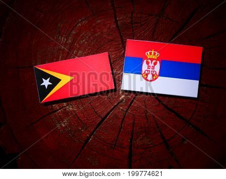 East Timorese Flag With Serbian Flag On A Tree Stump Isolated