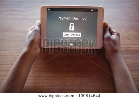 Payment declined and limit reached text on phone screen against cropped hands of woman using digital tablet