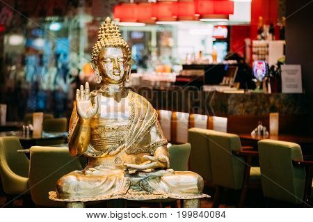Golden Statue Of Buddha Sitting In Lotus Position With Raised Right Arm Gesture Showing Dispute, Explaining Teachings Of Buddha Vitarka Mudra.