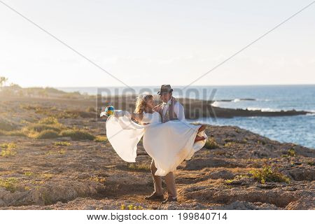 Cheerful married couple standing on the beach.