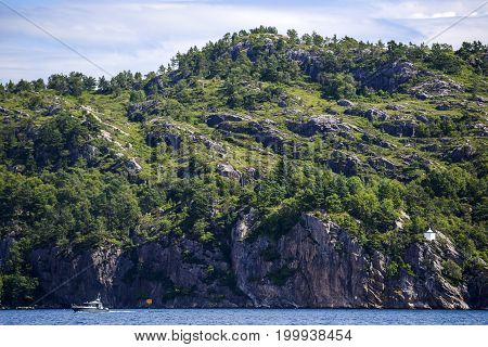 Landscape of the Norwegian coast water rocks and forest summer time.