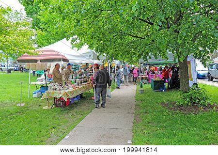 HAMILTON NEW YORK - MAY 27 2017: Vendors and shoppers at the local Saturday farmers market in the village of Hamilton near Colgate University in upstate New York.