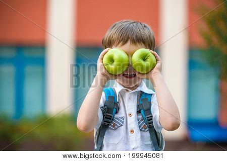 Child With Book And Green Apple Outdoors