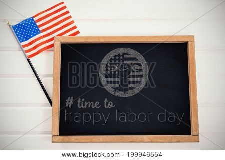 Digital composite image of time to happy labor day text against chalkboard and american flag on table