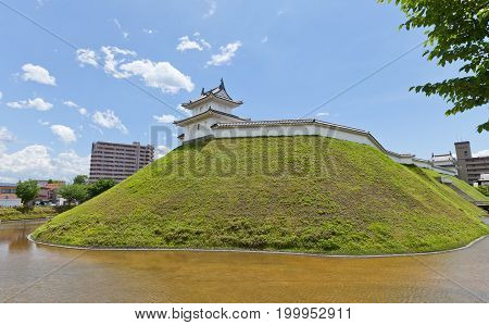 UTSUNOMIYA JAPAN - JUNE 2 2017: Reconstructed moat earthen wall and Seimeidai Turret of Utsunomiya Castle Japan. Castle was founded in 1062 destroyed in war of 1868 and reconstructed in 2007