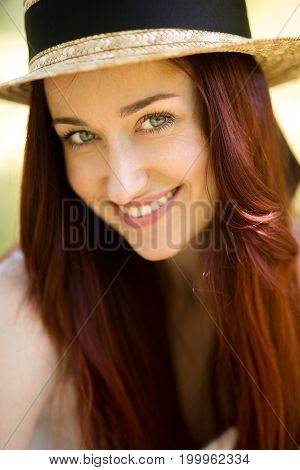 Close up portrait of sexy young lady in straw hat. Foxy woman with blue eyes happily smiling looking at camera. Toned image.