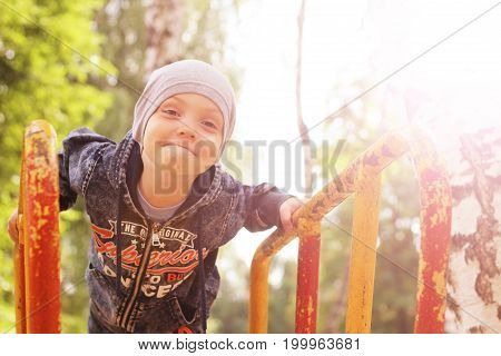 Portrait Of Little Boy On Nature Background Among Birches